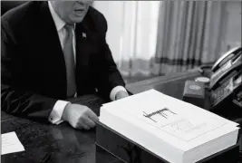  ?? ASSOCIATED PRESS ?? PRESIDENT DONALD TRUMP speaks with reporters after signing the tax bill and continuing resolution to fund the government, in the Oval Office of the White House Friday in Washington.