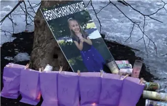  ?? AP FiLE ?? DEAL ON THE TABLE: A poster of Harmony Montgomery, who has been missing since 2019, rests against a tree during a candleligh­t vigil Feb. 12 in Manchester, N.H.