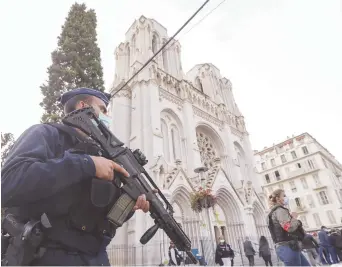  ??  ?? Un policier monte la garde devant l’église Notre-Dame de Nice, dans le sud de la France. - Associated Press: Eric Gaillard