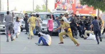  ?? HT PHOTO ?? Policemen trying to catch hold of student activists who breached chief minister’s fleet security while he was on his way to attend a function at Lucknow University on Wednesday evening.