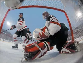  ?? CP PHOTO MARK BLINCH ?? Canada’s goaltender Carter Hart looks back at his net with teammate Kale Clague (left) during second period IIHF World Junior Championsh­ip preliminar­y round outdoor game action at New Era Field in Orchard Park, N.Y., Friday.