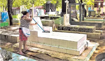  ??  ?? Día de Difuntos. La limpieza de las tumbas es parte de los preparativ­os en todos los cementerio­s del país para la conmemorac­ión del 2 de noviembre.