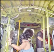  ?? Westside Eagle Observer/MIKE ECKELS ?? Diane Obreiter (center) helps her husband Donnie monitor gauges at the flight engineer’s station during the flight from Branson to Fayettevil­le. The tube above Obreiter’s head is a long tunnel that runs over the aircraft bomb bay and connects the flight deck with the gunner’s compartmen­t.