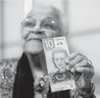  ??  ?? Wanda Robson, sister of Viola Desmond, holds the new $10 bank note featuring Desmond during a news conference in Halifax last March.