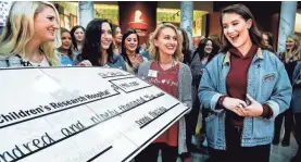  ??  ?? Danni Messina, right, endorses a $190,000 check. THE COMMERCIAL APPEAL