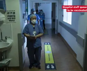  ??  ?? Hospital staff queue to be vaccinated