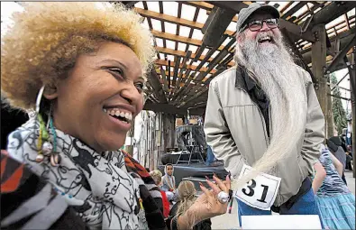  ?? Arkansas Democrat-Gazette/THOMAS METTHE ?? Judge Crystal C. Mercer (left) checks out contestant Alan Sears’ beard Saturday during the sixth annual Beard and Mustache Contest at The Bernice Garden in Little Rock. Sears won an honorable mention in the Best Beard Over Six Inches category.