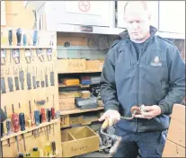  ?? GLEN WHIFFEN/THE TELEGRAM ?? Correction­al officer Steve Martin displays some of the older tools that have been in the HMP woodworkin­g shop for many years.