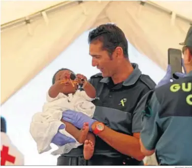  ?? ERASMO FENOY ?? Un guardia civil juega con un niño recién llegado en una patera.