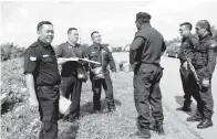  ??  ?? SHIVANANTH­AN (tengah) berbincang dengan anggota polis ketika memantau keadaan banjir di kawasan Sugut/ Paitan.