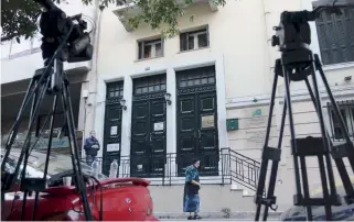  ??  ?? Cameras are seen yesterday outside the central Athens office of Michalis Zafeiropou­los, the prominent criminal lawyer who was shot dead on Thursday evening. Police have said the perpetrato­rs might have intended to only threaten him.