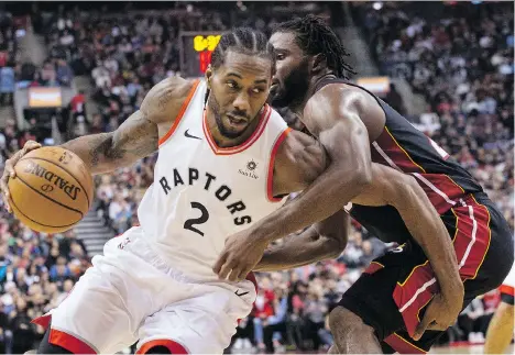  ?? CHRIS YOUNG/THE CANADIAN PRESS ?? Raptors forward Kawhi Leonard drives on the Miami Heat’s Justise Winslow last Sunday at Scotiabank Arena in Toronto. Leonard isn’t buying the hype ahead of today’s showdown with Golden State, calling it “just another game to build off of and get better.”