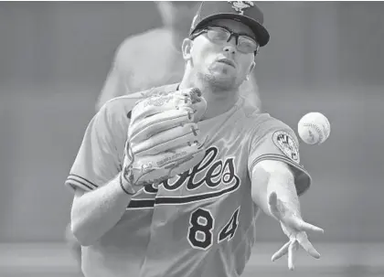  ?? LLOYD FOX/BALTIMORE SUN ?? Orioles pitcher Alex Wells tosses a ball to first base during field drills at the Ed Smith Stadium complex in Sarasota, Fla., on Feb. 14.