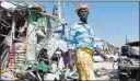  ?? FARAH ABDI WARSAMEH/ THE ASSOCIATED PRESS ?? A man walks past the wreckage of shops Sunday destroyed by a blast in a market in the Somali capital of Mogadishu. The explosion, which killed 34, bears the hallmarks of attacks by the Islamist extremist group al-Shabab.