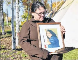  ?? NIKKI SULLIVAN/CAPE BRETON POST ?? Tricia Johnson holds a picture of her late sister, Cheryl Ann, during the opening ceremonies for the national inquiry into missing and murdered Indigenous women and girls, which takes place in Membertou from today until Wednesday.