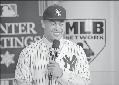  ?? Associated Press ?? All smiles: In this Dec. 11, 2017, file photo, New York Yankees player Giancarlo Stanton answers questions during a press conference at the Major League Baseball winter meetings in Orlando, Fla. Stanton was traded earlier this week to the Yankees from...