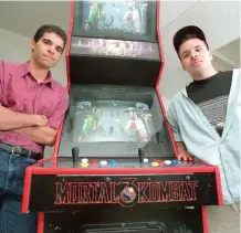  ?? SUN-TIMES FILE PHOTO ?? Ed Boon (left) and John Tobias of Midway Games in 1996 with the Mortal Kombat game they created. The fighting games are still being made in Chicago today by Netherreal­m Studios.