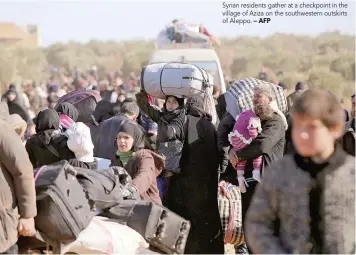  ?? — AFP ?? Syrian residents gather at a checkpoint in the village of Aziza on the southweste­rn outskirts of Aleppo.