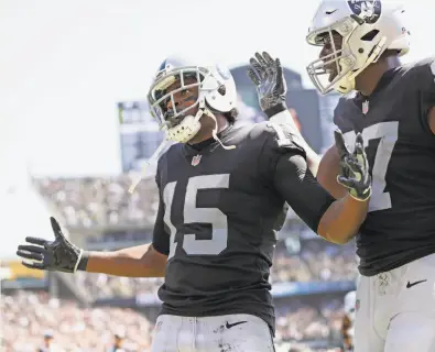  ?? Scott Strazzante / The Chronicle ?? Michael Crabtree (15), who matched his career high with three TD catches, celebrates a score with Jared Cook.