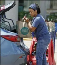  ?? ROGELIO V. SOLIS — THE ASSOCIATED PRESS ?? Whole Foods customer Bethany Capels, 34, of Mendenhall, Miss., loads her Whole Foods Market purchases in her car in Jackson, Miss., Friday.