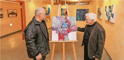  ?? RP-FOTO: JÜRGEN LAASER ?? Anton Krämer (rechts) zeigt dem ProArte-Vorsitzend­en Willi Arlt im „Gelben Haus“eines seiner vielfältig­en Werke. Künstler Krämer arbeitet mit Kreide, Kohle, Bleistift ebenso wie mit Acryl, Öl, Tempera und Tusche.