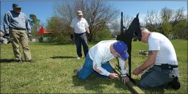  ?? NWA Democrat-Gazette/ANDY SHUPE ?? John Thompson (from right), Bob Ashbaugh, Rick Johnson and Gary Burney install 10 silhouette­s of Civil War soldiers near the site of the main spring in Elm Springs. Nearly 10,000 Confederat­e soldiers camped here the night before the Battle of Pea...