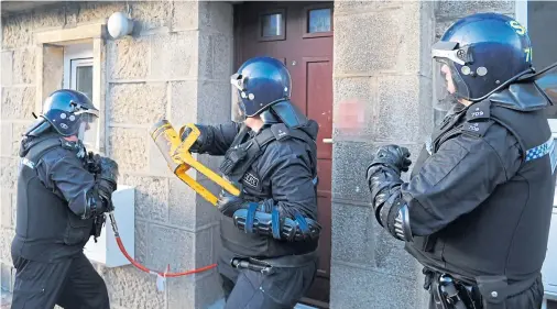  ?? Photograph by Darrell Benns ?? ENFORCEMEN­T: Police officers raiding a property in Fraserburg­h – one of the towns English dealers often target.