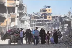  ?? ASSOCIATED PRESS ?? Palestinia­ns walk through the destructio­n in the wake of an Israeli air and ground offensive in Khan Younis, southern Gaza Strip, Monday. Israel says it has withdrawn its last ground troops from the city, ending a four-month operation.