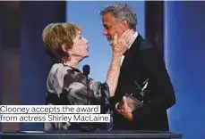  ?? Photos by Reuters, AFP and AP ?? Clooney accepts the award from actress Shirley MacLaine.