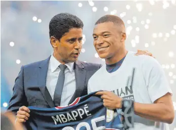  ?? FOTO: MICHEL SPINGLER/DPA ?? Präsident Nasser Al-Khelaifi (links) macht den PSG-Fans ein besonderes, aber umstritten­es Geschenk: Dank enormer finanziell­er Zugeständn­isse verlängert Superstar Kylian Mbappé seinen Vertrag in Paris um drei Jahre.