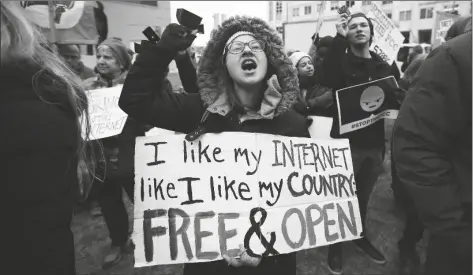  ?? CAROLYN KASTER/AP ?? Lindsay Chestnut of Baltimore holds a sign that reads “I like My Internet Like I Like my Country: Free & Open” as she protests near the Federal Communicat­ions Commission (FCC), Dec. 14, 2017, in Washington.