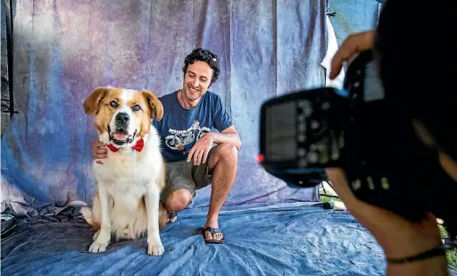  ?? PHOTO: BRADEN FASTIER/ FAIRFAX NZ ?? Chris Phillips with his SPCA dog Hooch have their photo taken by Kathy
Pantling of Dirty Dog pet photograph­y at Isel Park during the twilight Christmas Markets on Thursday in Stoke.