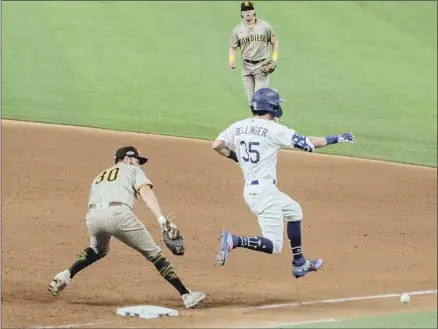  ?? Robert Gauthier Los Angeles Times ?? DODGERS’
Cody Bellinger is safe at f irst on an errant throw from Padres’ Jake Cronenwort­h, allowing Justin Turner to score.