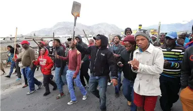  ?? PICTURE: HENK KRUGER/AFRICAN NEWS AGENCY (ANA) ?? SIMMERING: Crowds of people marching down Vrygrond Avenue on a day of violent protest action in the area. Residents are threatenin­g more action next month if demands for land are not met.