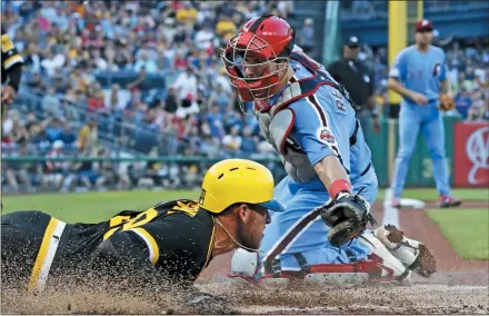  ?? GENE J. PUSKAR — THE ASSOCIATED PRESS ?? Pirates starting pitcher Joe Musgrove, left, scores past the tag attempt by Phillies catcher J.T. Realmuto during the third inning of a game Saturday night in Pittsburgh.