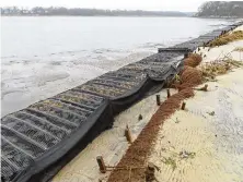  ?? AP ?? Logs of coconut husk known as coir sit on the bank of the Shark River in Neptune, N.J., where the American Littoral Society has a shoreline restoratio­n project using coconut fibers. The material is used in similar projects around the world.