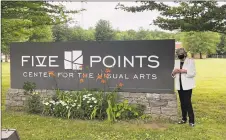  ?? Five Points Gallery / Contribute­d photo ?? Five Points executive director Judith McElhone stands by the new sign at the former UConn Torrington campus.