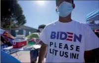  ?? GREGORY BULL / AP ?? A Honduran man seeking asylum in the United States wears a shirt that reads, “Biden please let us in,” as he stands among tents that line an entrance to the border crossing on March 1 in Tijuana, Mexico.