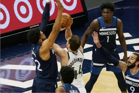  ??  ?? Minnesota Timberwolv­es' Karl-Anthony Towns , left, defends as Utah Jazz's Bojan Bogdanovic (44) attempts to shoot in the first half of an NBA basketball game, Monday, April 26, 2021, in Minneapoli­s. (AP Photo/Jim Mone)