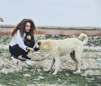  ??  ?? Painter Şeyma Kayan feeds a stray dog in central Konya, Turkey, April 13, 2021.