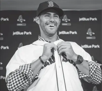  ?? Photo by Billie Weiss |Boston Red Sox ?? J.D. Martinez buttons up his new Red Sox jersey during a press conference in Florida on Monday. After four months of anticipati­on, with $110 million on the line and one of the game’s great sluggers in contractua­l limbo, the deal is finally done.