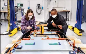  ?? (AP/Photo Courtesy of Ford) ?? This photo provided by Ford shows Dane Hardware, Ford Motor Co. design and release engineer, and Mary Fredrick, Ford Motor Co. battery validation engineer, measuring the voltage of a battery using a digital multi-meter at Ford’s Battery Benchmarki­ng and Test Laboratory in Allen Park, Mich., in early April.