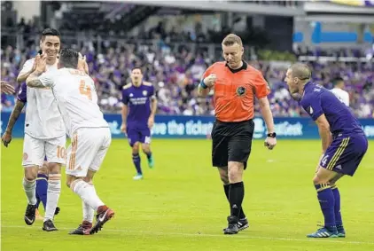  ?? DOUGLAS DEFELICE/USA TODAY SPORTS ?? As Atlanta United players celebrate a foul call that would lead to a penalty-kick goal, Orlando City’s Will Johnson, right, voices his displeasur­e.