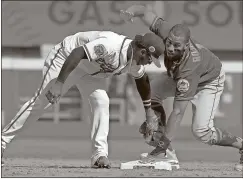  ?? Tami Chappell / The Associated Press ?? The New York Mets’ Amed Rosario (right) steals second base as Atlanta’s Ozzie Albies applies the late tag in the ninth inning of Sunday’s game in Atlanta.