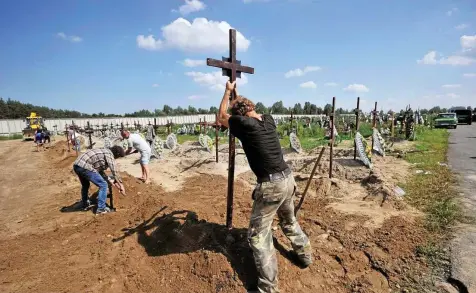  ?? SERGEI CHUZAVKOV / AFP ?? Friedhof von Butscha: Grab um Grab heben die Arbeiter aus, um die vielen Leichen beerdigen zu können, die im Februar und März bei Massakern in dem Dorf bei Kiew ums Leben gekommen sind.