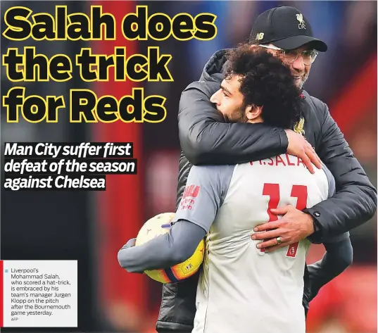  ?? AFP ?? Liverpool’s Mohammad Salah, who scored a hat-trick, is embraced by his team’s manager Jurgen Klopp on the pitch after the Bournemout­h game yesterday.