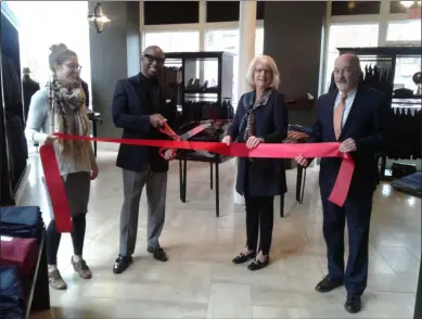  ?? MELISSA SCHUMAN - MEDIANEWS GROUP ?? Marcus Golston and city officials prepare to cut the ribbon for Britches of Troy.