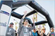  ?? Caroline Brehman ?? Las Vegas Review-journal Sarah Neumann cheers while crossing the start line Sunday at the Vegas Strong 5K/1 mile, hosted by Jus Run.
