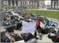  ?? DANIELLE EPTING -- FOR DIGITAL FIRST MEDIA ?? Students hold up signs, “We Should Be Preparing for Tests Not Death” and “Books Not Bullets” during a lie-in Friday in remembranc­e of the Columbine victims at the state capitol in Albany.