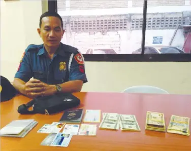  ?? PHOTO FROM GMA-7 ?? SPO2 Isagani Ceniza with the money and other items he found inside a taxicab.